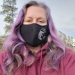 A woman with purple hair wearing the Build Your Face Mask.