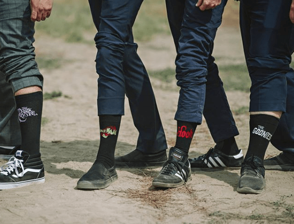 A group of men wearing black and white socks and stylish Custom Wedding Ties.