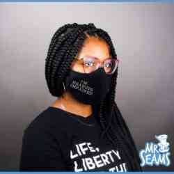 A woman wearing an "I'm Deaf, I'm Hearing Impaired" face mask and a black t-shirt.