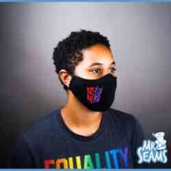 A woman wearing a black Decepticon Autobot Face Mask with the words "mr seams" on it, resembling a Decepticon.