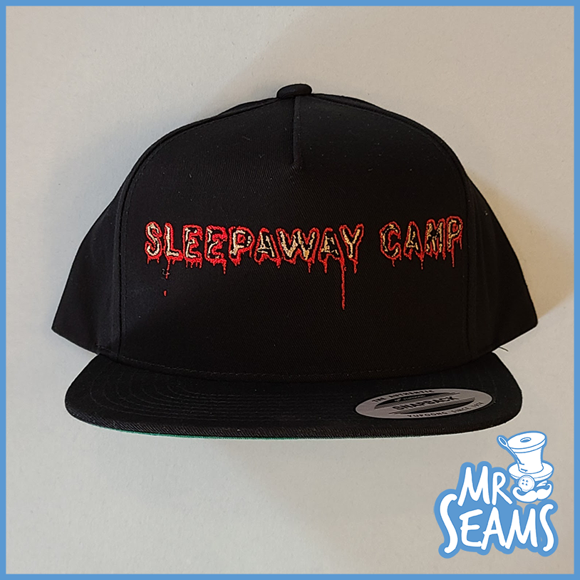 A black Sleepaway Camp beanie or hat with the words Sleepaway Camp on it.