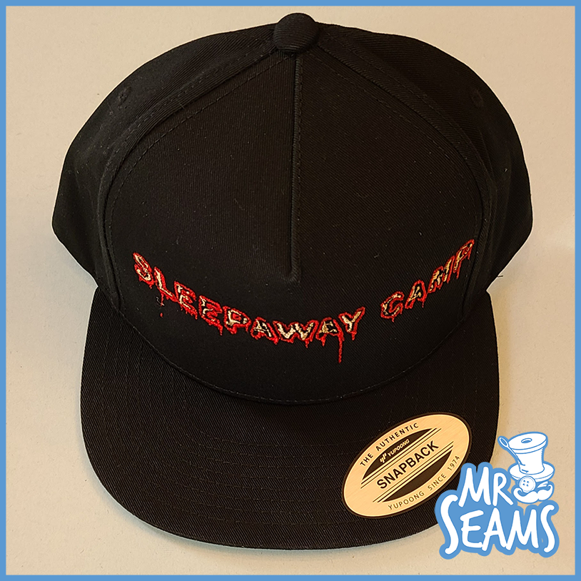 A black snapback hat with the words "sleepaway camp" embroidered on it. Sleepaway Camp Beanies & Hats