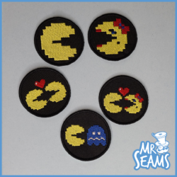 Four pacman embroidered patches on a black background.