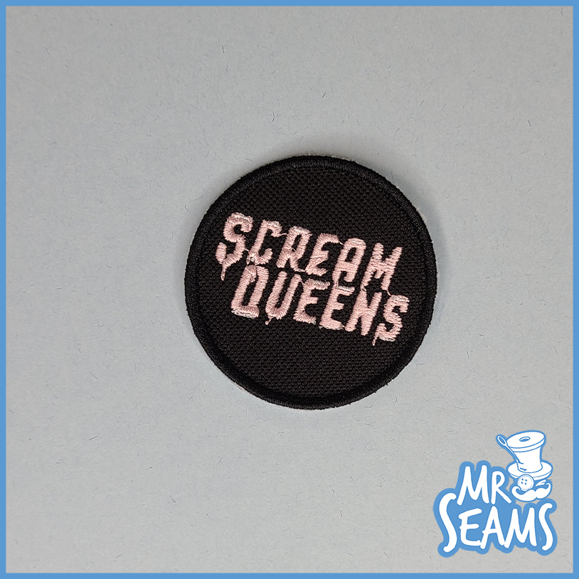 A patch with the word scream queens on it.