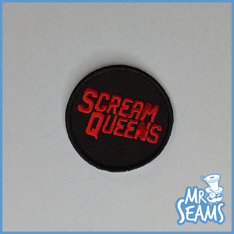 A patch with the word scream queens on it.