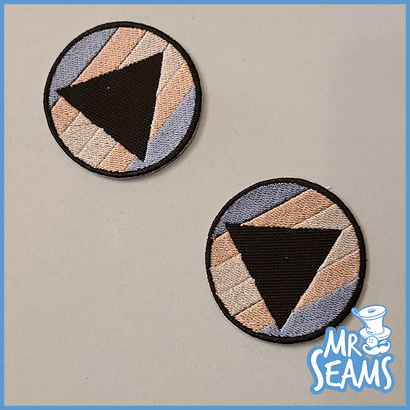 Two Pride Triangle Patches with embroidery designs.