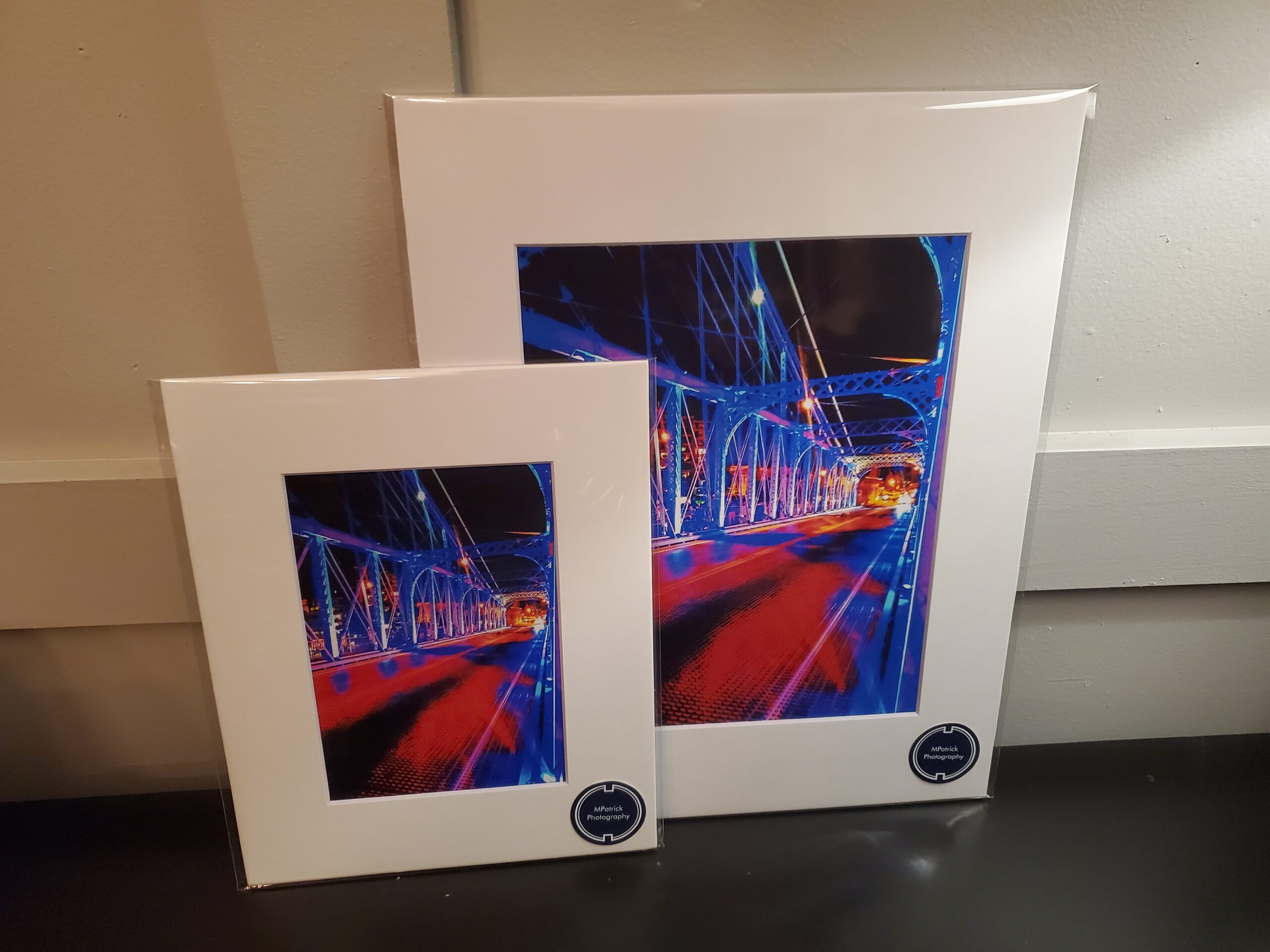 A pair of framed pictures showcasing the Roebling Tower @ BLINK against a vibrant blue background, capturing the mesmerizing lights of BLINK.