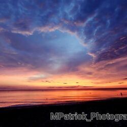 A Fairytale Sunset over the ocean with clouds in the sky.